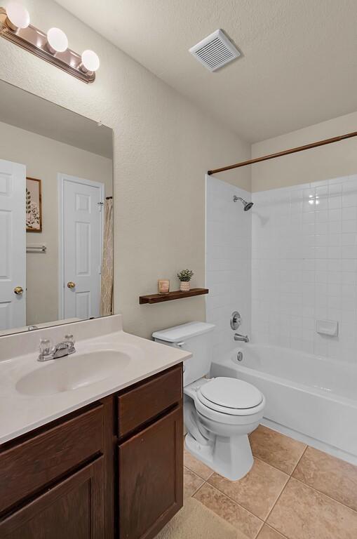 6608 Costa Dr, Waco, TX 76712 - full bathroom with vanity, toilet, tile patterned floors, and  shower combination