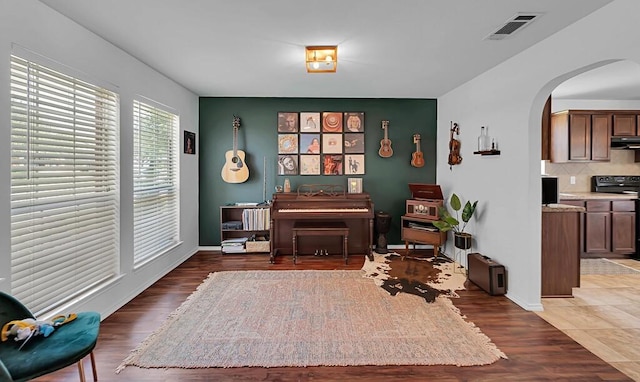 6608 Costa Dr, Waco, TX 76712 - sitting room with arched walkways, light wood finished floors, and baseboards