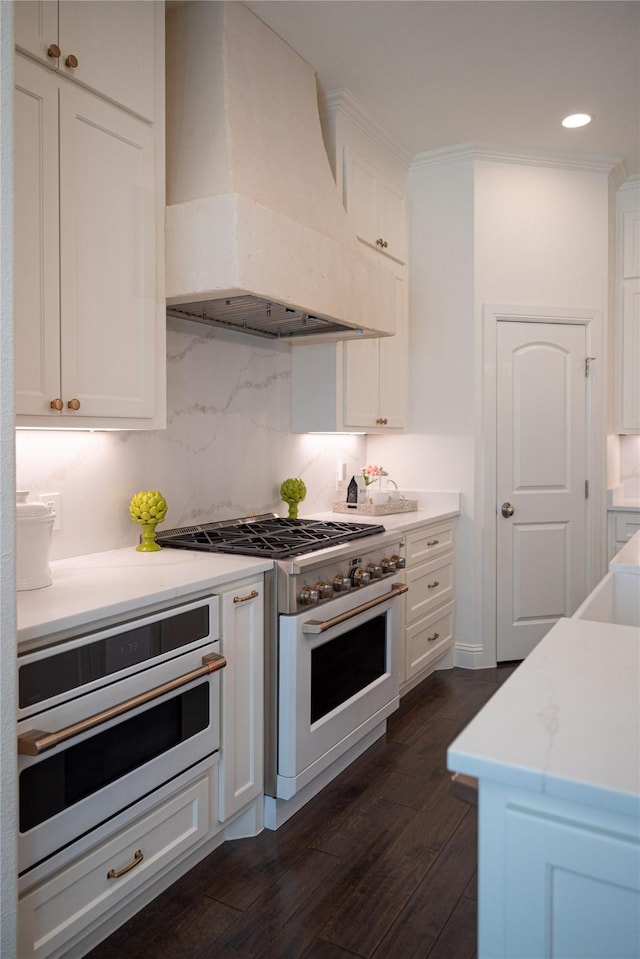 6032 Forest Ln, Fort Worth, TX 76112 - kitchen with custom range hood, white appliances, white cabinetry, dark wood-style flooring, and light countertops