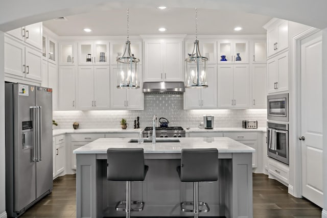 8112 Western, The Colony, TX 75056 - kitchen featuring appliances with stainless steel finishes, under cabinet range hood, dark wood-type flooring, white cabinets, and recessed lighting