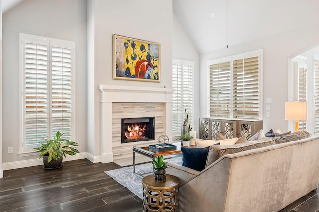 8112 Western, The Colony, TX 75056 - living room with dark wood-style floors, high vaulted ceiling, a tile fireplace, baseboards, and arched walkways