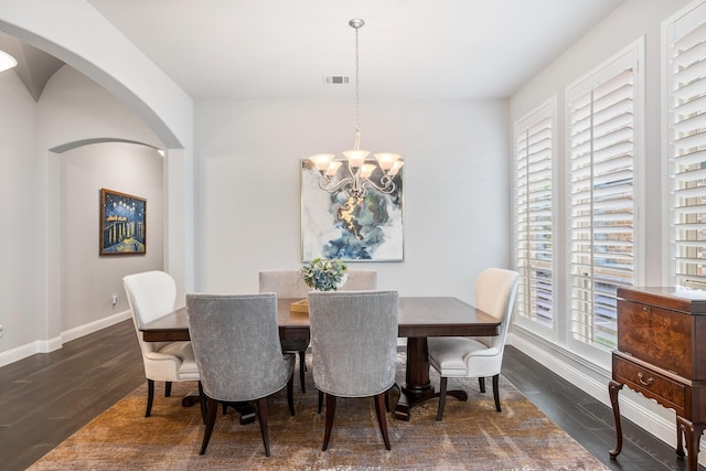 8112 Western, The Colony, TX 75056 - dining room featuring arched walkways, a chandelier, baseboards, and dark wood-style flooring