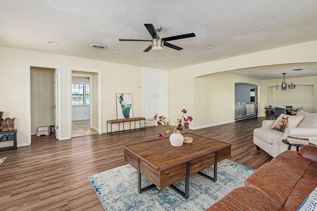 10 Estates Rd, Lucas, TX 75002 - living room with arched walkways, a ceiling fan, wood finished floors, baseboards, and a textured ceiling