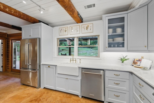 127 Pleasant Valley Ln, Weatherford, TX 76087 - kitchen featuring appliances with stainless steel finishes, track lighting, a sink, glass insert cabinets, and light stone countertops