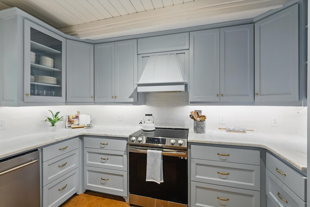 127 Pleasant Valley Ln, Weatherford, TX 76087 - kitchen with appliances with stainless steel finishes, premium range hood, gray cabinets, backsplash, and glass insert cabinets