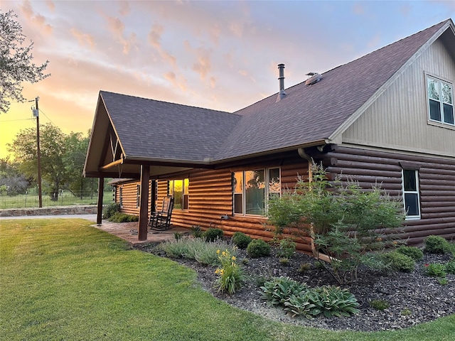 127 Pleasant Valley Ln, Weatherford, TX 76087 - property exterior at dusk with a shingled roof, a lawn, and log siding