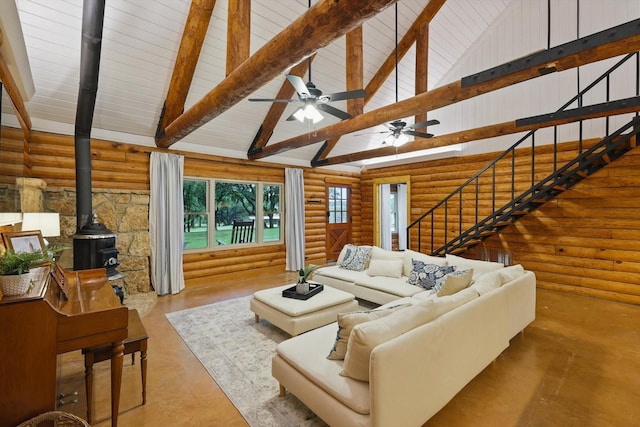 127 Pleasant Valley Ln, Weatherford, TX 76087 - living room with a wood stove, log walls, high vaulted ceiling, stairs, and concrete floors