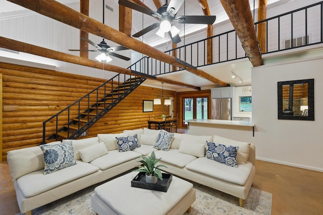 127 Pleasant Valley Ln, Weatherford, TX 76087 - living room with a high ceiling, log walls, ceiling fan, baseboards, and stairs