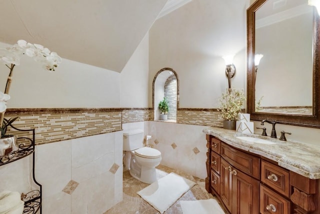 1751 Bison Meadow Ln, Heath, TX 75032 - bathroom featuring tile walls, vanity, toilet, a wainscoted wall, and tile patterned flooring