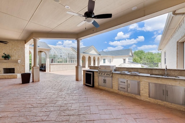 1751 Bison Meadow Ln, Heath, TX 75032 - view of patio / terrace with beverage cooler, a ceiling fan, a sink, and an outdoor stone fireplace