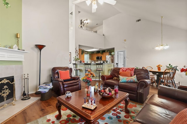 408 Autumn Park Park, Fort Worth, TX 76140 - living area with wood finished floors, ceiling fan, a chandelier, high vaulted ceiling, and a tile fireplace