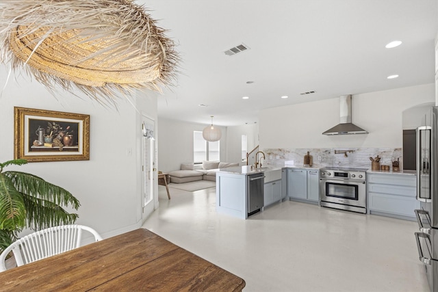16012 Alvarado Dr, Prosper, TX 75078 - kitchen with stainless steel appliances, wall chimney range hood, backsplash, light countertops, and a peninsula