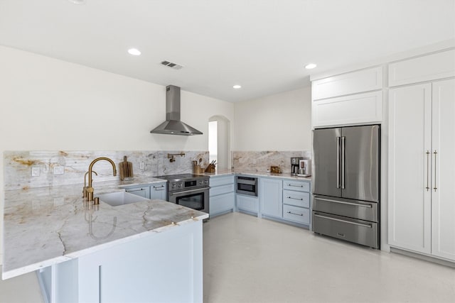 16012 Alvarado Dr, Prosper, TX 75078 - kitchen with stainless steel appliances, wall chimney exhaust hood, a sink, light stone countertops, and white cabinets