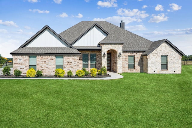 1308 Green Ridge Rd, Weatherford, TX 76085 - view of front of property featuring a front yard, roof with shingles, board and batten siding, a chimney, and brick siding