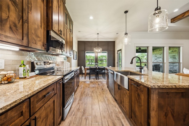 1308 Green Ridge Rd, Weatherford, TX 76085 - kitchen featuring stainless steel appliances, a sink, light wood-style flooring, backsplash, and light stone counters
