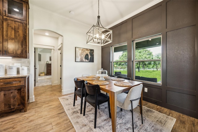 1308 Green Ridge Rd, Weatherford, TX 76085 - dining space featuring arched walkways, crown molding, light wood-style floors, and a chandelier