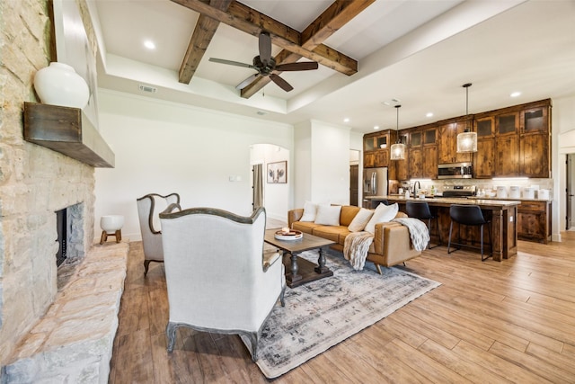 1308 Green Ridge Rd, Weatherford, TX 76085 - living area featuring recessed lighting, beam ceiling, arched walkways, light wood-type flooring, and ceiling fan
