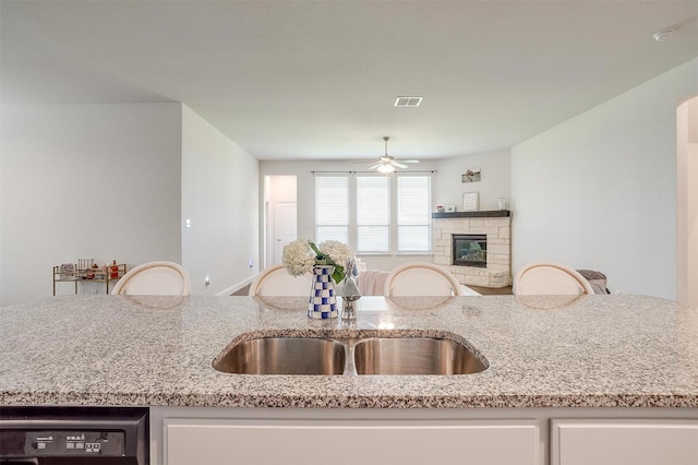 15125 Belclaire Ave, Aledo, TX 76008 - kitchen with a sink, open floor plan, ceiling fan, light stone countertops, and a stone fireplace