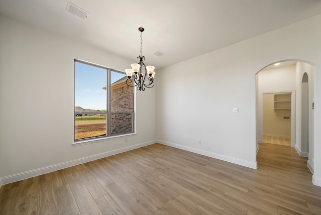 411 Solo Ridge Dr, Waxahachie, TX 75167 - empty room featuring arched walkways, light wood-style flooring, and a chandelier