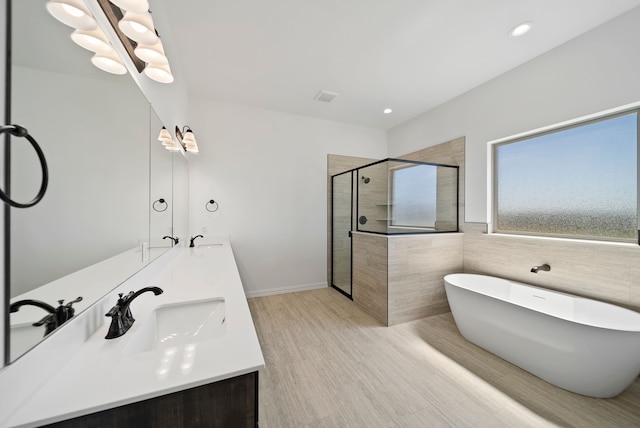 411 Solo Ridge Dr, Waxahachie, TX 75167 - full bathroom featuring a stall shower, a freestanding bath, double vanity, wood finished floors, and tile walls