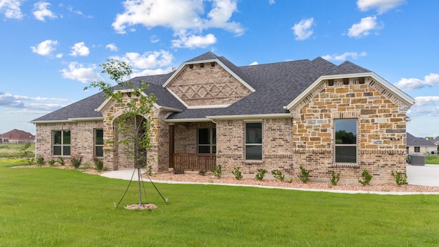 411 Solo Ridge Dr, Waxahachie, TX 75167 - view of front facade featuring a front lawn, a shingled roof, brick siding, and stone siding