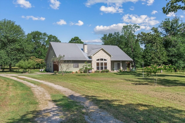 10040 Fm 17, Grand Saline, TX 75140 - view of front facade featuring a front yard, a chimney, metal roof, driveway, and stone siding