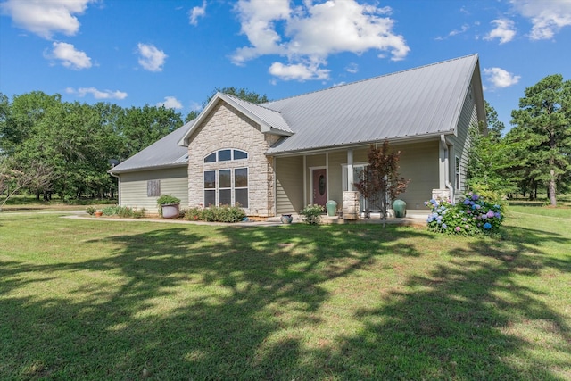 10040 Fm 17, Grand Saline, TX 75140 - view of front of house with a porch, stone siding, a front yard, and metal roof