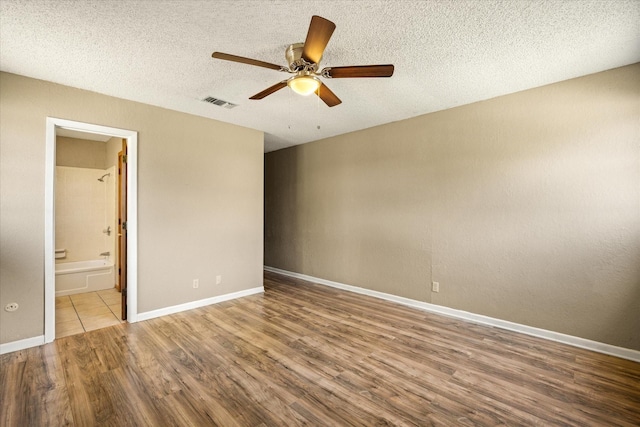 1023 Holmes Dr, Granbury, TX 76048 - empty room with wood finished floors, a ceiling fan, a textured ceiling, and baseboards