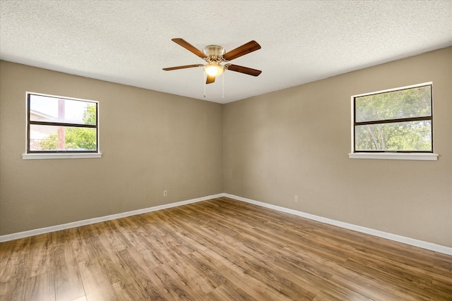 1023 Holmes Dr, Granbury, TX 76048 - spare room with plenty of natural light, wood finished floors, baseboards, ceiling fan, and a textured ceiling
