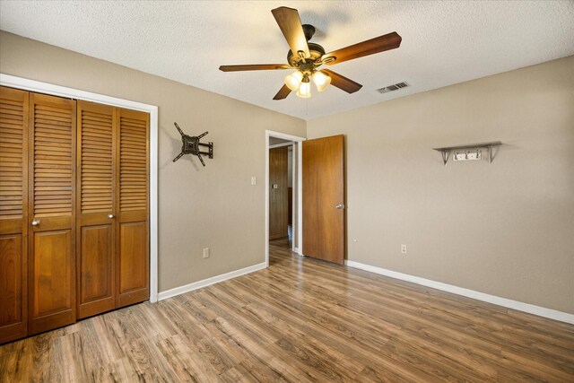 1023 Holmes Dr, Granbury, TX 76048 - unfurnished bedroom featuring light wood finished floors, baseboards, a closet, a textured ceiling, and ceiling fan
