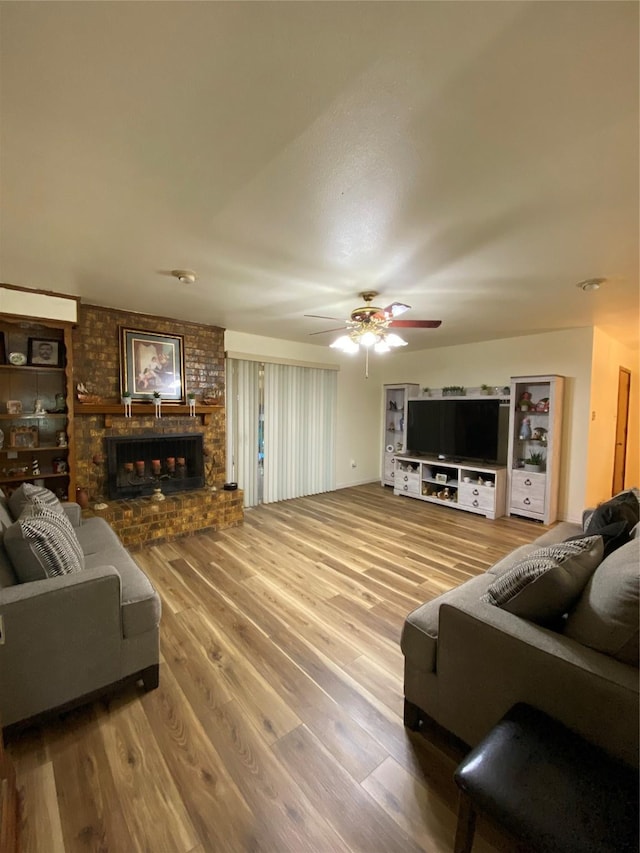 1203 Springbrook Cir, Desoto, TX 75115 - living room featuring wood finished floors, a brick fireplace, and a ceiling fan