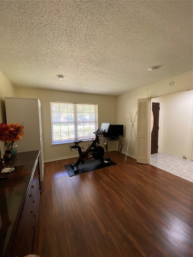 1203 Springbrook Cir, Desoto, TX 75115 - workout area with a textured ceiling, wood finished floors, and baseboards