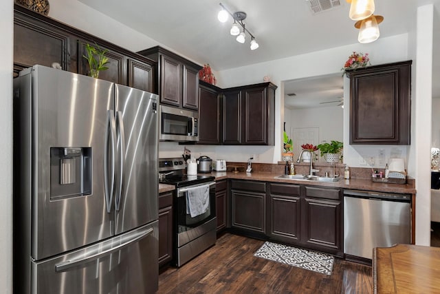 1213 Alder Tree Ln, Royse City, TX 75189 - kitchen with stainless steel appliances, a sink, dark brown cabinets, dark countertops, and dark wood-style floors