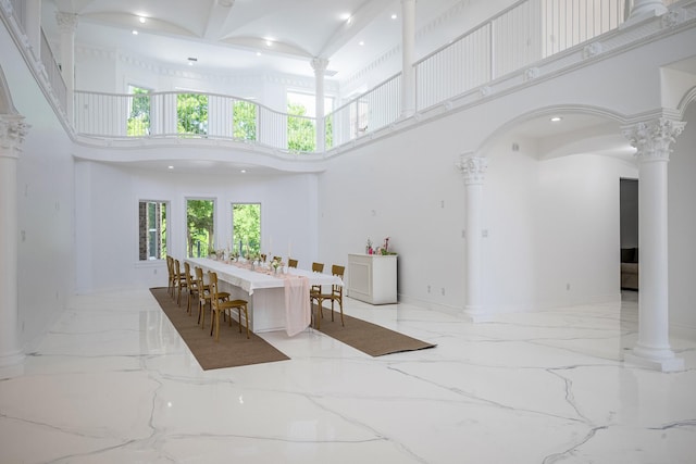 2415 Amberleaf Ct, Cedar Hill, TX 75104 - dining room with decorative columns, a towering ceiling, marble tiled flooring, baseboards, and arched walkways