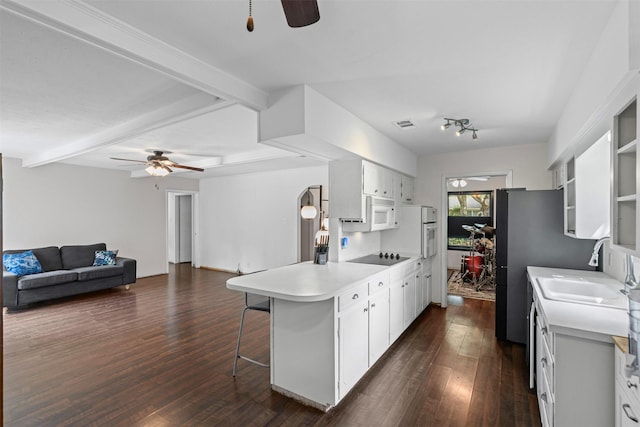 103 Auburn St, Waxahachie, TX 75165 - kitchen with ceiling fan, a peninsula, dark wood-style floors, a kitchen bar, and beamed ceiling