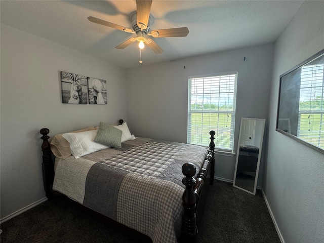 706 Jefferson Ave, Cisco, TX 76437 - bedroom with baseboards, dark colored carpet, and a ceiling fan