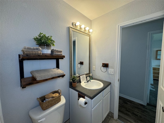 706 Jefferson Ave, Cisco, TX 76437 - bathroom with vanity, toilet, and wood finished floors