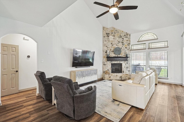 6015 Liverpool St, Celina, TX 76227 - living area featuring a ceiling fan, arched walkways, high vaulted ceiling, wood finished floors, and a stone fireplace