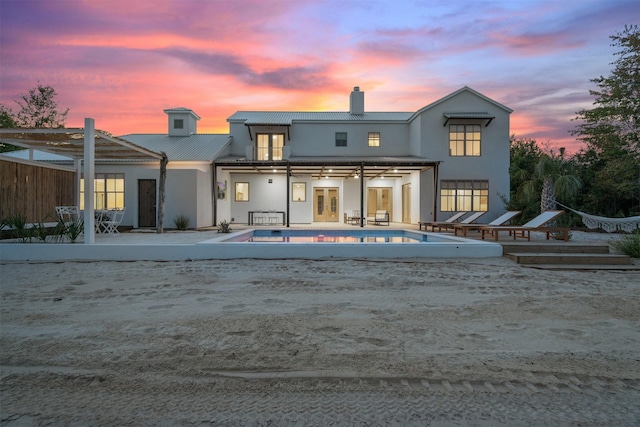 23538 Kate Ln, Arp, TX 75750 - back of house at dusk featuring french doors, an outdoor pool, a chimney, stucco siding, and a patio