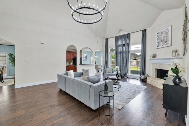8620 Thistle Ridge Ter, Fort Worth, TX 76123 - living room featuring arched walkways, a high end fireplace, dark wood-type flooring, a chandelier, and high vaulted ceiling