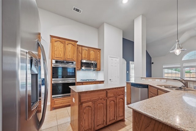 2110 Pecan Ridge Dr, Forney, TX 75126 - kitchen with stainless steel appliances, decorative backsplash, a sink, brown cabinetry, and high vaulted ceiling