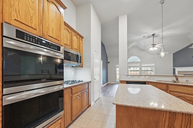 2110 Pecan Ridge Dr, Forney, TX 75126 - kitchen with appliances with stainless steel finishes, a sink, decorative backsplash, ceiling fan, and a center island