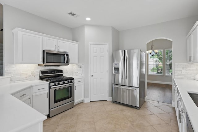 6808 Edgefield Dr, Denton, TX 76210 - kitchen featuring stainless steel appliances, white cabinets, light countertops, decorative backsplash, and a chandelier