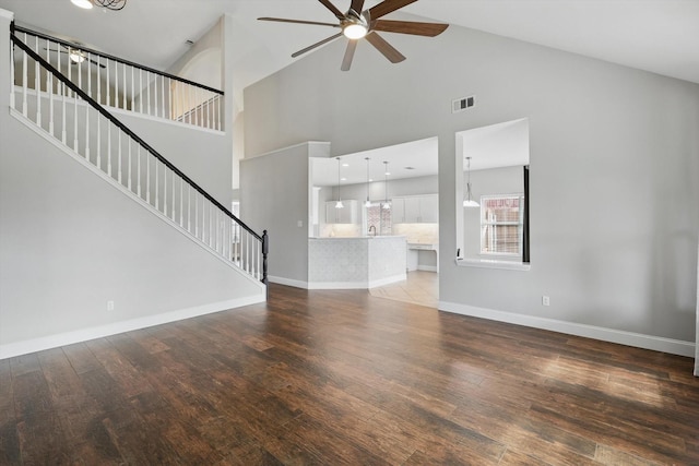 6808 Edgefield Dr, Denton, TX 76210 - unfurnished living room with ceiling fan, stairway, wood finished floors, high vaulted ceiling, and baseboards