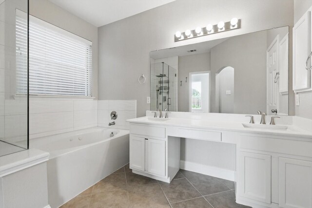 6808 Edgefield Dr, Denton, TX 76210 - bathroom featuring a garden tub, double vanity, tile patterned floors, and a stall shower