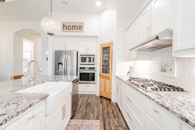 1406 Darlington Ln, Forney, TX 75126 - kitchen featuring appliances with stainless steel finishes, under cabinet range hood, a sink, arched walkways, and white cabinetry