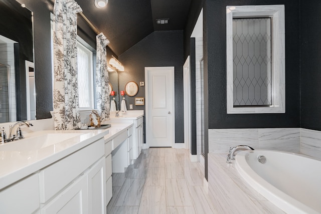 1406 Darlington Ln, Forney, TX 75126 - full bathroom with vaulted ceiling, double vanity, a bath, a stall shower, and a textured wall