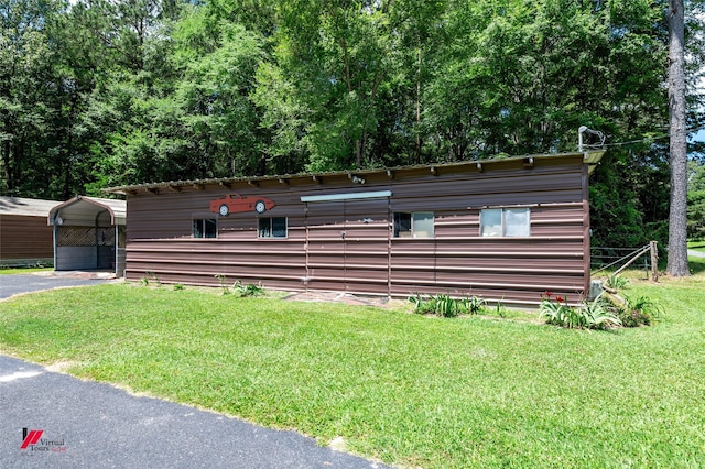 255 Barry Rd, Logansport, LA 71049 - view of front of house with a front yard, a detached carport, an outbuilding, and asphalt driveway