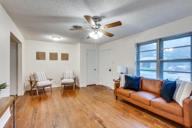 7612 Oxley Dr, Richland Hills, TX 76118 - living room featuring light wood-style floors, a textured ceiling, a ceiling fan, and baseboards