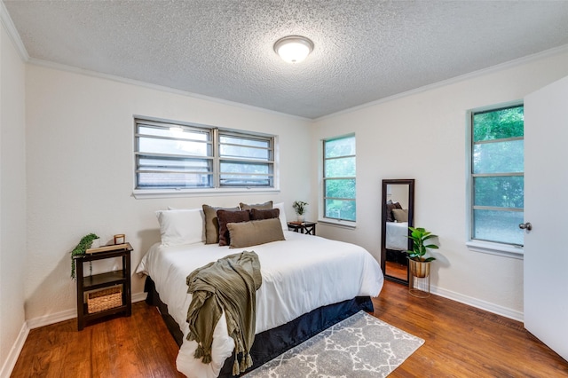 7612 Oxley Dr, Richland Hills, TX 76118 - bedroom featuring ornamental molding, a textured ceiling, wood finished floors, multiple windows, and baseboards